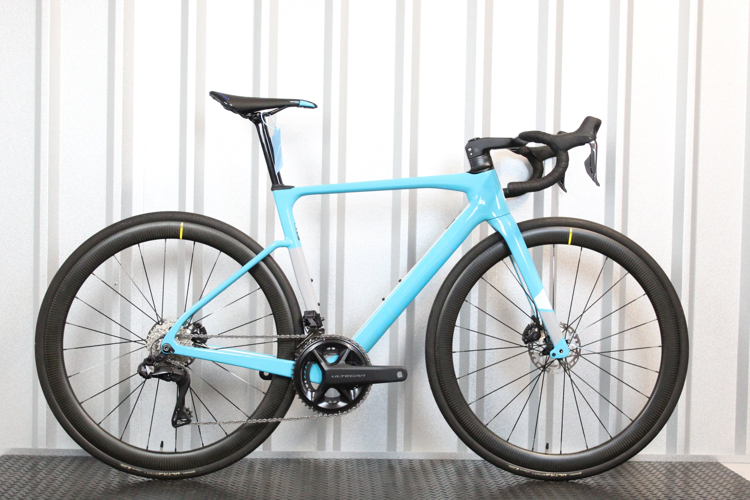 Light blue bicycle with black components on a white background